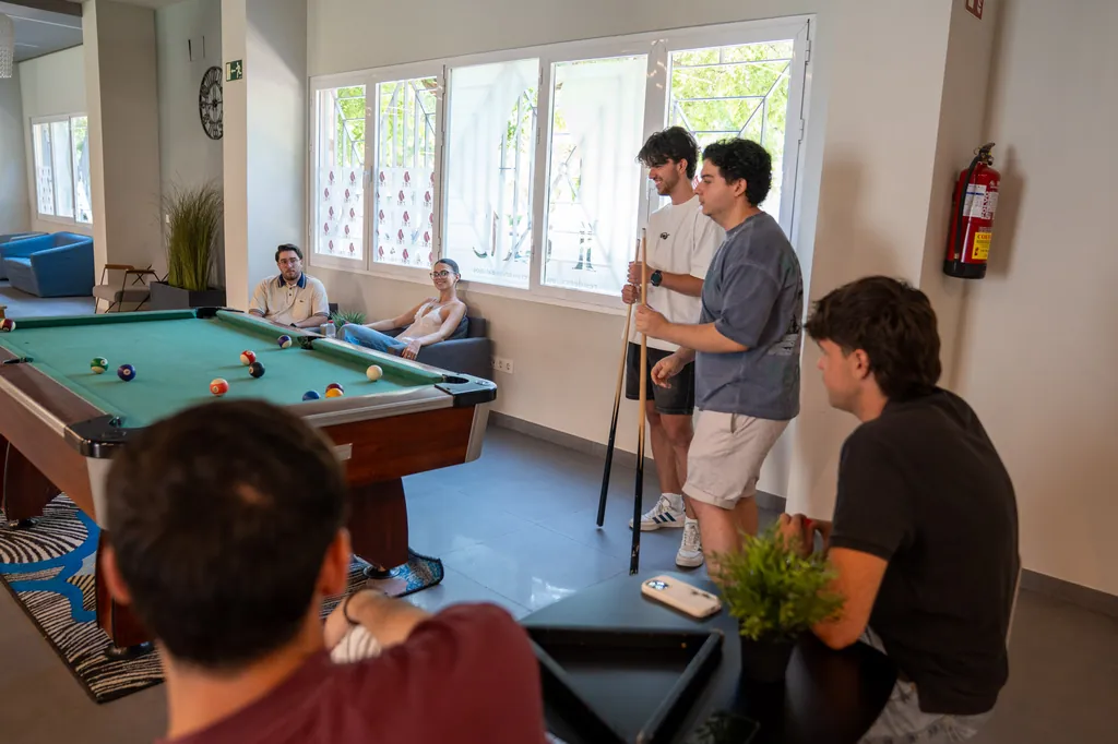 Estudiantes jugando al billar en la sala de ocio de la residencia